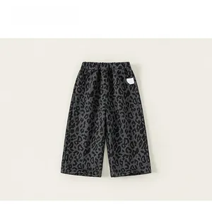 Detailed view of elastic waistband and leopard print on grey kids wide-leg trousers