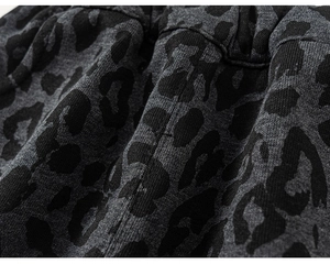 Detailed macro view of dark grey leopard print fabric with elastic waist stitching