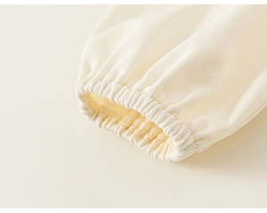 Détail d'une manche en tulle crème avec poignet élastique montrant une texture de maille fine