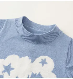 Detalle del chaleco de punto azul con patrones de estrellas y cuello de canalé