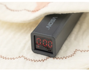 Macro view of handheld fluorescence detector testing beige knitted fabric with 0.00 display