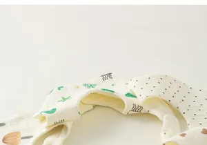 Close-up of soft multi-layer cotton baby bibs with cute cartoon prints and snap buttons