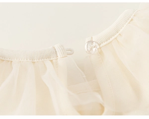 Détail de l'encolure de robe en tulle blanc crème avec bordure côtelée et fermeture à bouton