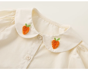 Detalle de camisa para niña con cuello Peter Pan y bordado de zanahoria