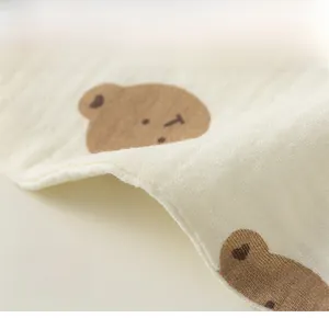 Detail showing breathable cotton fabric and cute bear print on baby floral bib
