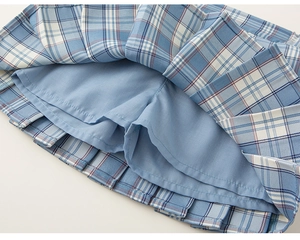 Detalle de falda plisada a cuadros azules para niña con pantalón de seguridad interior