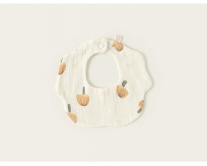 Detail of cream petal bib featuring brown mushroom patterns and snap button closure