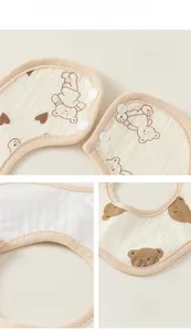 Detail view of baby bib showing waterproof layer, stitching, and bear print pattern