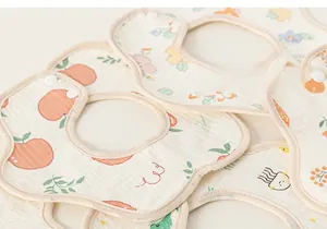 Detail of soft cotton baby bibs with cartoon patterns and adjustable snap closure