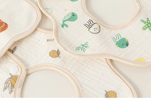Close-up of baby bib with marine life patterns showing soft cotton gauze texture