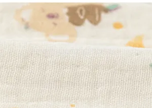 Detailed macro view of soft cotton gauze fabric with cute cartoon koala print for babies