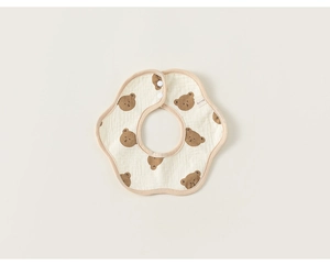 Detail of soft cotton baby bib with bear print, petal shape, and snap fastener closure