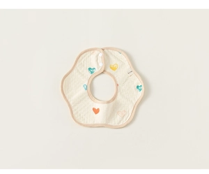 Detail view of cotton floral petal bib with colorful heart patterns and snap buttons