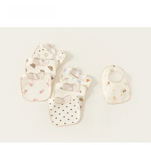 Detail showing various soft cotton baby bibs with cute cartoon bear and bunny prints