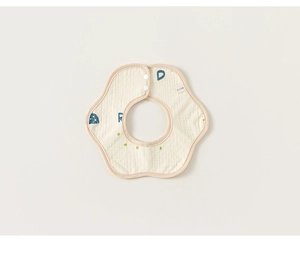Detail of petal-shaped muslin baby bib with letter patterns and resin snap buttons