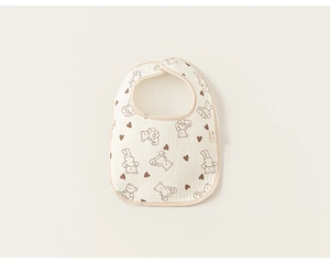 Detail of baby cotton bib featuring cute cartoon bear pattern and soft gauze texture