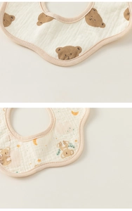 Detailed macro view of petal-shaped cotton gauze baby bibs with bear and koala prints