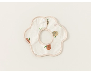 Detail of petal-shaped cotton gauze baby bib with orange pumpkin prints and snap button