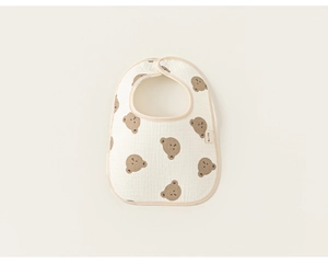 Close-up of baby petal bib in cream cotton with brown cartoon bear prints and snap button