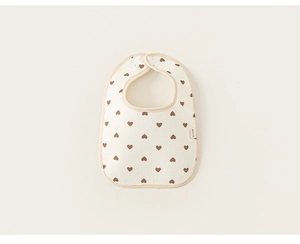 Detail of baby bib with brown hearts pattern and secure snap button closure
