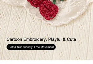 Detail of baby girl knitted shirt showing openwork fabric and red cherry embroidery