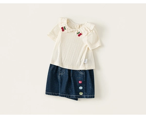 Detail of baby girl summer outfit showing ruffled lace collar and cherry embroidery work