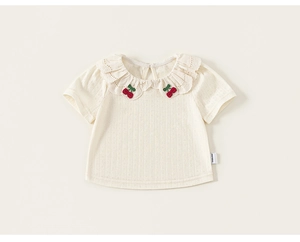 Close-up of lace ruffle collar and cherry embroidery on white girls' cotton T-shirt