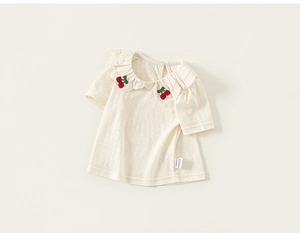 Close-up of lace collar with cherry embroidery on beige toddler cotton t-shirt