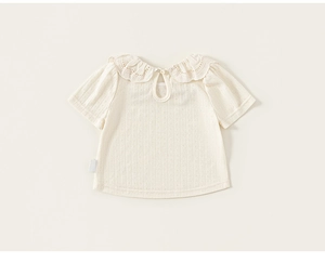 Detail of baby girl summer tee with lace Peter Pan collar and dotted texture fabric