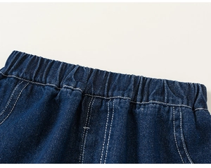 Detail of elastic waistband and white stitching on navy blue denim kid trousers