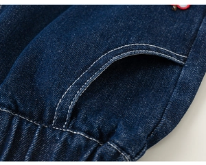 Detail of dark blue denim fabric with white topstitching and elastic waistband finish