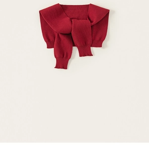 Detail of a vintage red knitted scarf shawl with ribbed cuffs for children and toddlers
