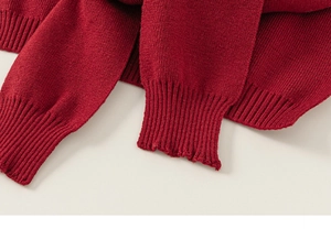 Detailed close-up of dark red knitted fabric showing high-quality ribbed cuffs and hem