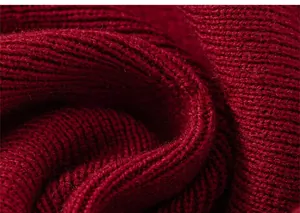 Close-up detail of vintage red chunky knit fabric with textured ribbed pattern