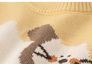 Dettaglio del gilet in maglia giallo zenzero con motivi jacquard di animali cartone