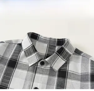 Dettaglio del colletto della camicia a quadri in bianco e nero con bottoni e trama fine
