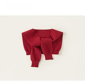 Detail of burgundy knitted shawl featuring fine ribbing and elegant wrap design