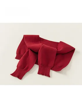 Detail view of deep red knitted shawl collar with ribbed edges and soft yarn texture