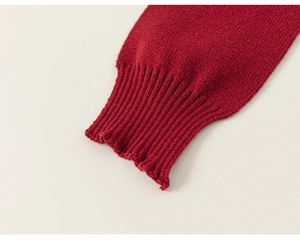Detail of dark red knitted sleeve cuff showing the ribbed texture and fine cotton weave