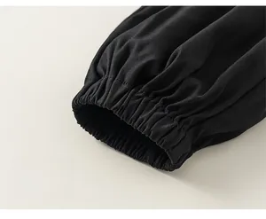 Dettaglio dei polsini elastici neri sui pantaloni da bambino in tessuto twill nero