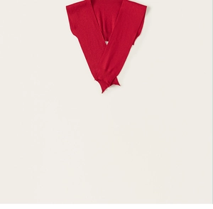 Detail view of red knitted shawl for kids featuring ribbed edges and flat stitch craft