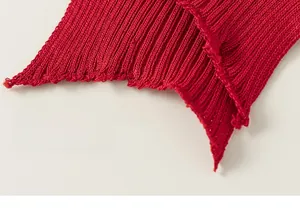 Close-up of red knit shawl with detailed ribbed texture and frayed edge design