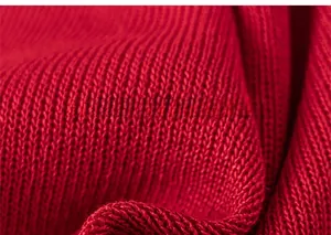 Close-up of red ribbed knit fabric showing detailed texture and premium yarn craft
