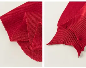 Detail of red knit shawl showing tight woven texture and distressed fringe edges