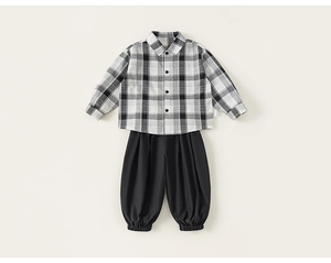 Dettaglio piatto di camicia a quadri e pantaloni jogger neri per completi da bambino