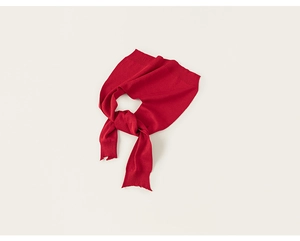Detail of red knit shawl with ribbed cuffs and soft texture on white background