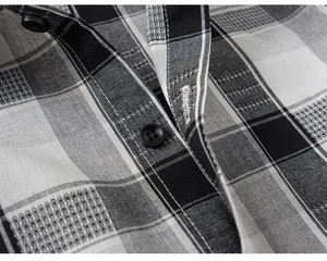 Vista macro del tessuto in misto cotone con bottoni neri su camicia a quadri bimbo