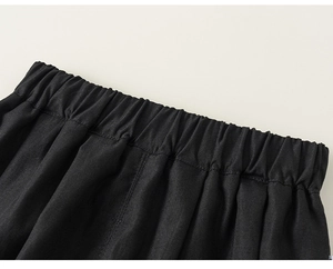 Dettaglio ravvicinato dell'elastico in vita con trama twill su pantaloni neri da bambino