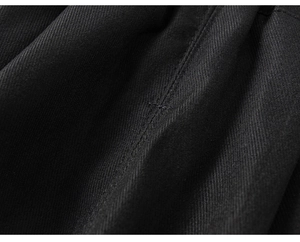 Dettaglio del tessuto twill nero e delle cuciture rinforzate sui pantaloni da bambino