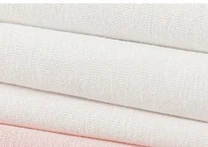 Nahaufnahme von weichen weißen und rosa Strickstoffschichten für Kinder-T-Shirts